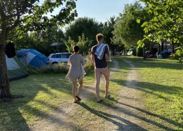 un homme et une femme, serviette sur l'épaule, vue de dos en marchant dans le camping.