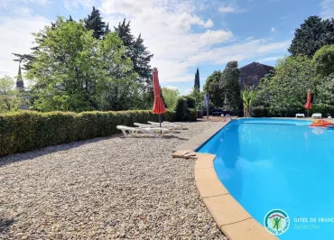 Grande piscine commune aux gîtes avec vue sur le clocher du village