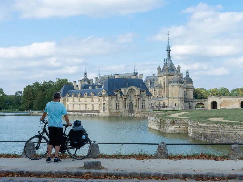 Cycliste devant le château de Chantilly