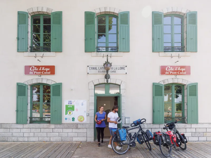 Cyclistes sortant du gîte d'étape Accueil Vélo du pont canal de briare