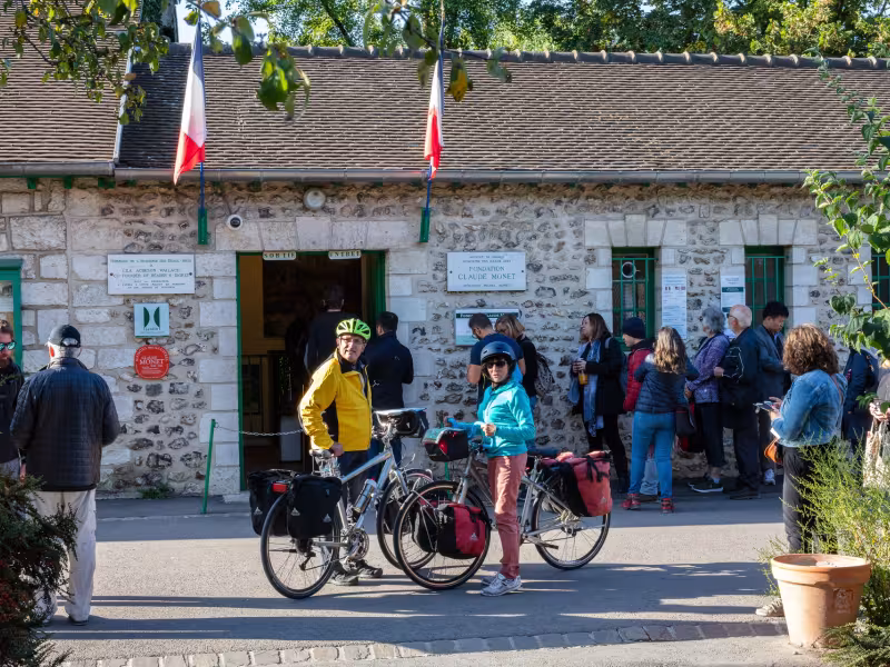 Voyageurs à vélo devant l'entrée de la maison de Claude Monet à Giverny