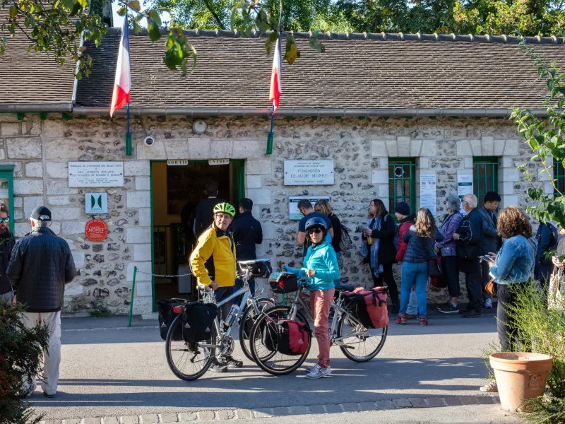 Voyageurs à vélo devant l'entrée de la maison de Claude Monet à Giverny