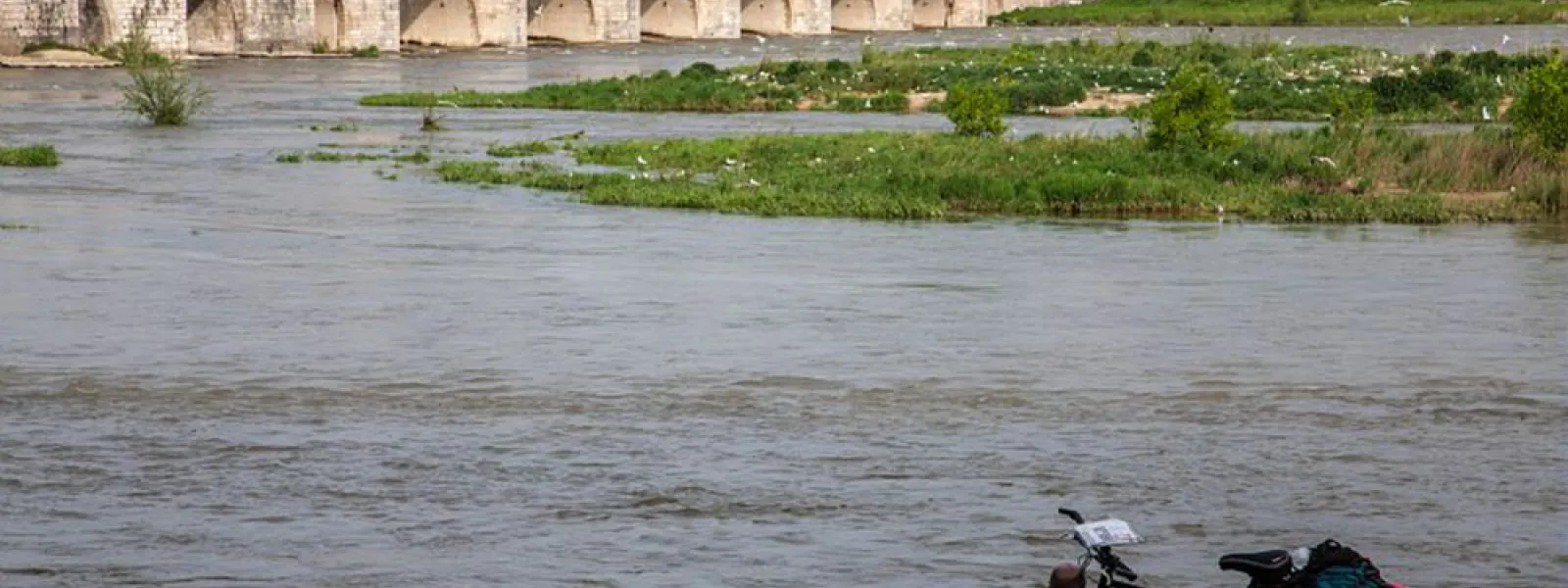 Pause d'un voyageur à vélo près d'un pont sur Loire - Beaugency