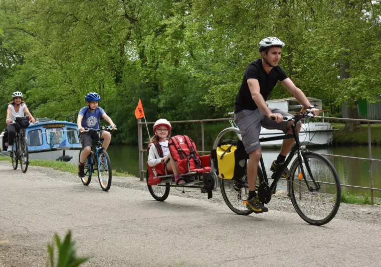 Famille à vélo avec enfants et remorque