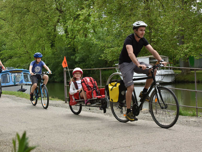 Famille à vélo avec enfants et remorque